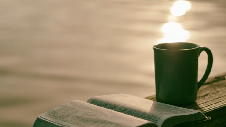 green ceramic mug beside book